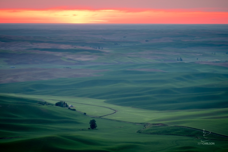 The sun turns crimson at the end of the day over Palouse farmland as seen from Steptoe Butte.